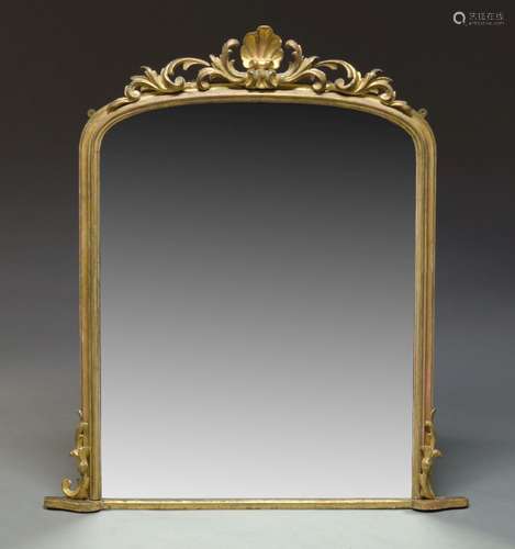 A large giltwood overmantle mirror, early 19th Century, of arched form with carved scrolling foliate