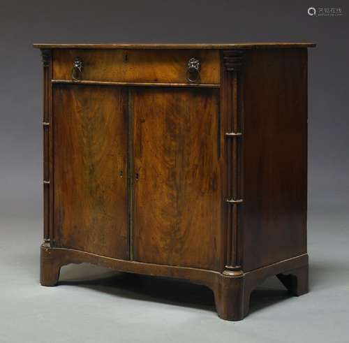 A George III mahogany serpentine fronted cupboard, with single frieze drawer above two cupboard