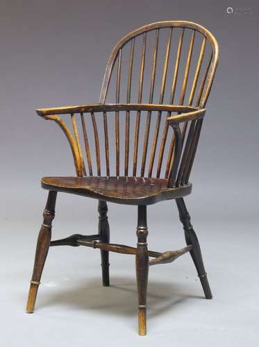 A Victorian ash and yew wood Windsor armchair, with hooped spindle back, above saddle seat on turned