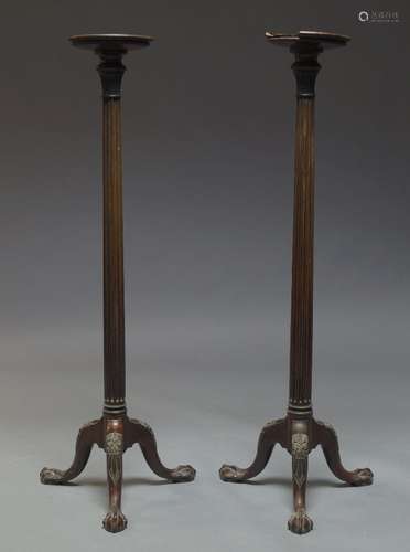 A pair of George III style mahogany torchère stands, 20th Century, the circular tops on fluted