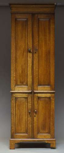 A Victorian oak cabinet, the moulded cornice above two panelled cupboard doors, each enclosing three