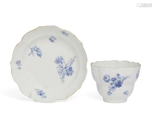 A Meissen dry blue glazed cup and saucer, 18th century, with shaped rim to cup and saucer, painted