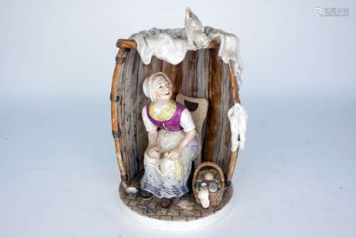 A Continental pottery figure of a woman seated in a barrel, 19th century, she modelled wearing a