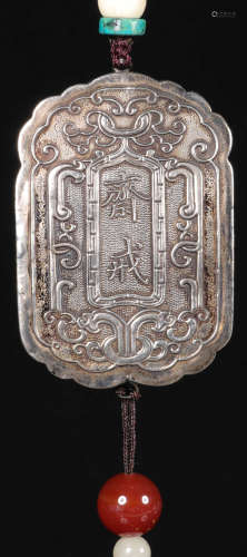 A SILVER TABLET WITH CARVING