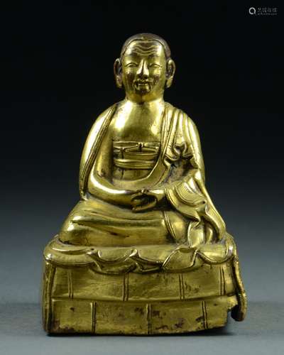 TIBETAN GILT BRONZE SEATED FIGURE OF A LAMA, 17/18TH C.