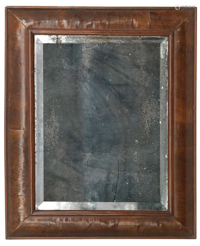 An early 18th century walnut cushion framed wall mirror