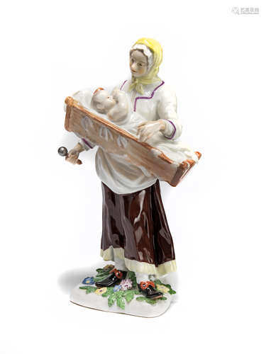 A Meissen figure of a mother holding a child in a crib Circa 1760