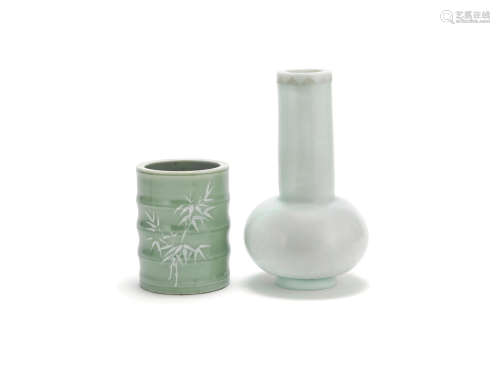 A very pale blue glass bottle and a celadon-glazed and slip-decorated porcelain brush pot, bitong   Qing Dynasty or later, the vase with incised Qianlong four-character mark