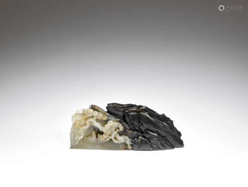 A black and pale green jade carving of a mountain