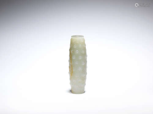 A pale green and russet jade archaistic bead