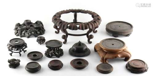 Property of a gentleman - a group of fourteen Chinese carved hardwood stands and a cover, 19th