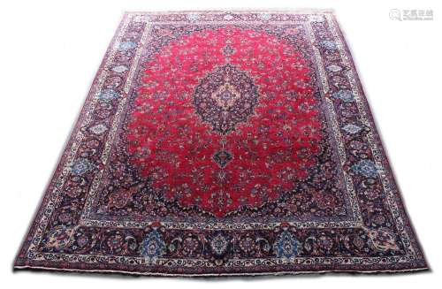 A Meshed woollen hand-made carpet with red gound, 153 by 115ins. (387 by 290cms.).