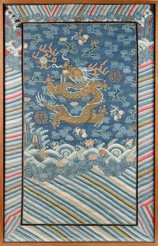 A 19th century Chinese kesi panel depicting a dragon chasing a flaming pearl above waves,