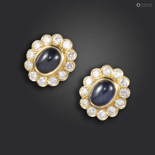 A pair of sapphire and diamond cluster earrings, set with cabochon sapphires within a surround of