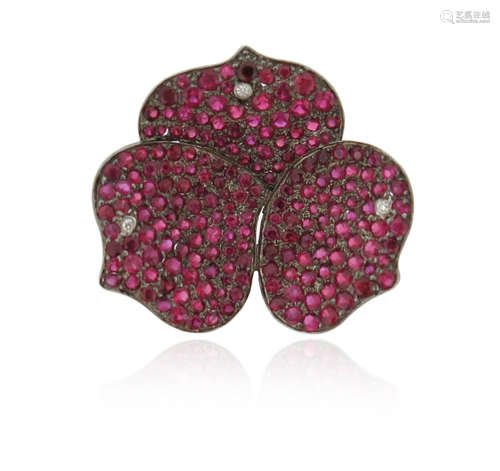 A ruby and diamond flower head pendant, pave-set with circular-cut rubies and a diamond to each