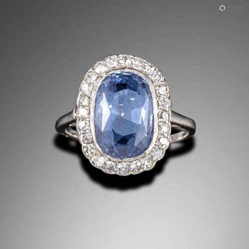 A sapphire and diamond cluster ring, the cushion-shaped sapphire is set within a surround of