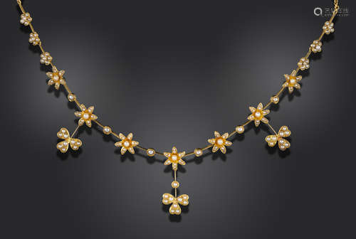 An Edwardian seed pearl-set gold necklace, with seed pearl-set flowers on knife-edge links,