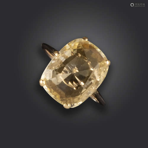 A sapphire solitaire ring, the cushion-shaped yellow sapphire claw-set in yellow gold, size L