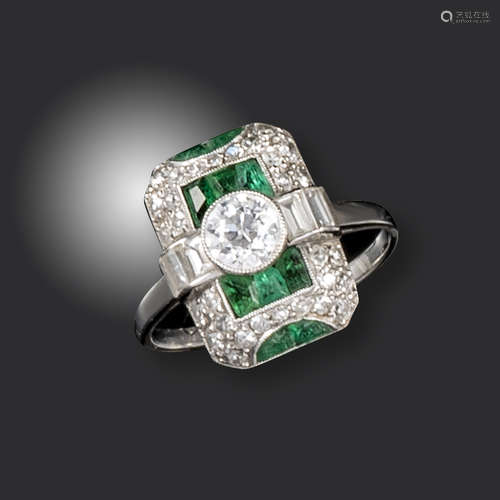 An Art Deco emerald and diamond ring, set with an old circular-cut diamond flanked with baguette-