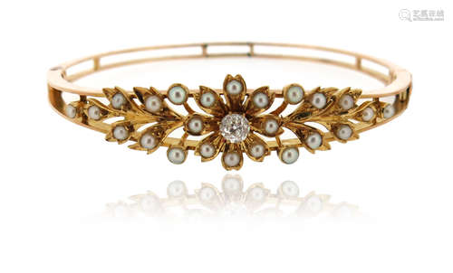 An Edwardian seed pearl and diamond bangle, of laurel design in yellow gold, 5.7cm inner diameter