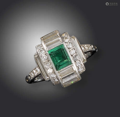 An Art Deco emerald and diamond ring, centred with a baguette-shaped emerald between six baguette-