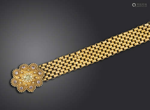 A Regency gold bracelet, the clasp set with pink topazes and a green stone within gold filigree
