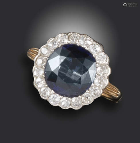 A Victorian sapphire and diamond cluster ring, the cushion-shaped sapphire set within a surround