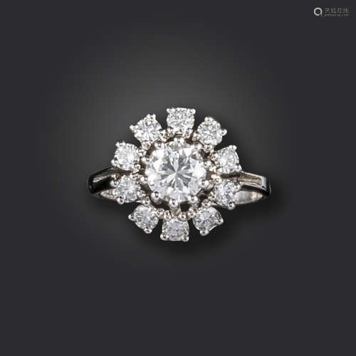 A diamond cluster ring, the round brilliant-cut diamond weighs approximately 0.60cts, set within a