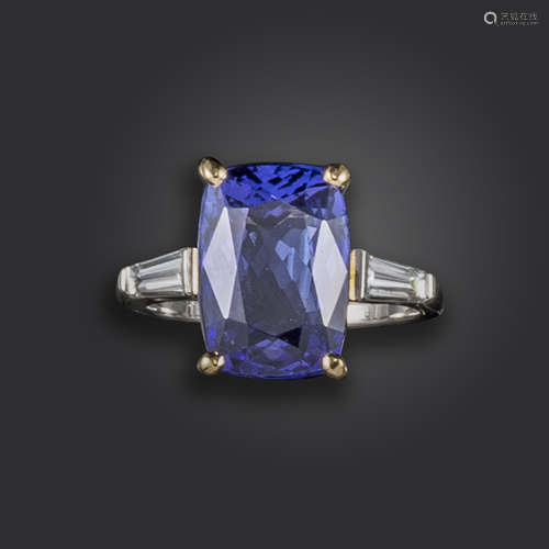 A tanzanite and diamond three-stone ring, set with a cushion-shaped tanzanite weighing approximately