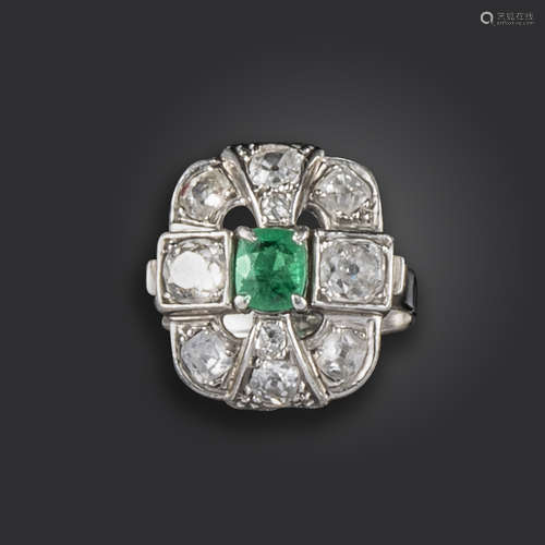 An emerald and diamond ring, of quatrefoil openwork design, set with a cushion-shaped emerald, and