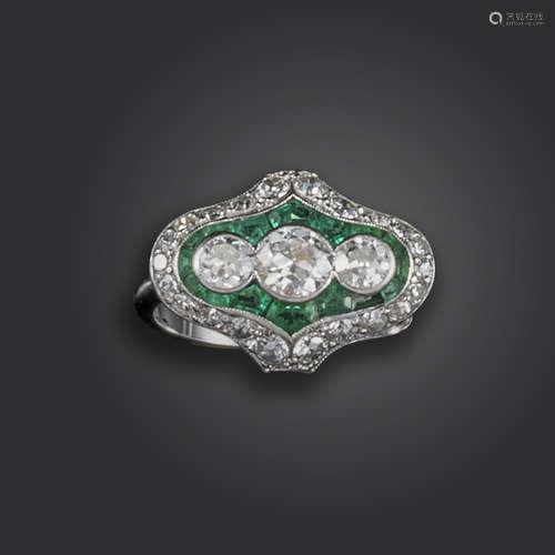 An emerald and diamond cluster ring, centred with three graduated old circular-cut diamonds within a