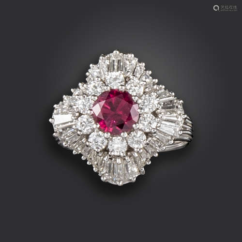 A ruby and diamond cluster ring, the circular-cut ruby set within a surround of circular-cut