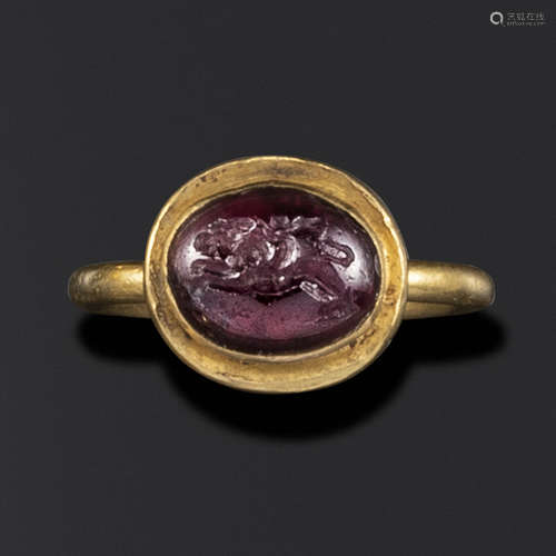 A Hellenistic domed garnet intaglio of Eros riding a lion, c2nd-1st century BC, in a late Roman gold