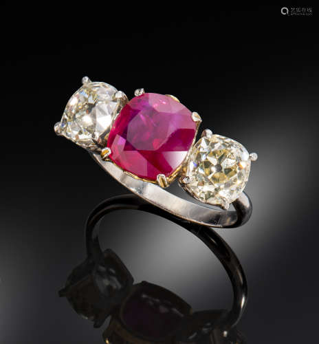 A ruby and diamond three-stone ring, the cushion-shaped ruby weighs 3.14cts, set with two cushion-