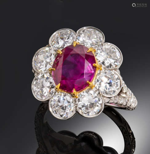 A ruby and diamond cluster ring, the oval-shaped ruby weighs approximately 3.20cts and is set with