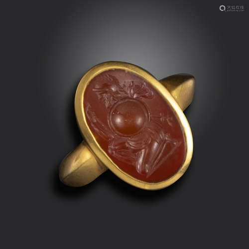 A Roman carnelian intaglio depicting a kneeling warrior, c1st century BC - 1st century AD, the