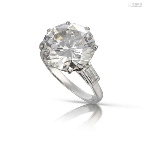 A diamond solitaire ring, the round brilliant-cut diamond weighs 6.92cts, set with two baguette-