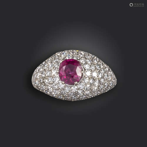 A ruby and diamond bombé ring, the cushion-shaped ruby set within domed surround pave-set with