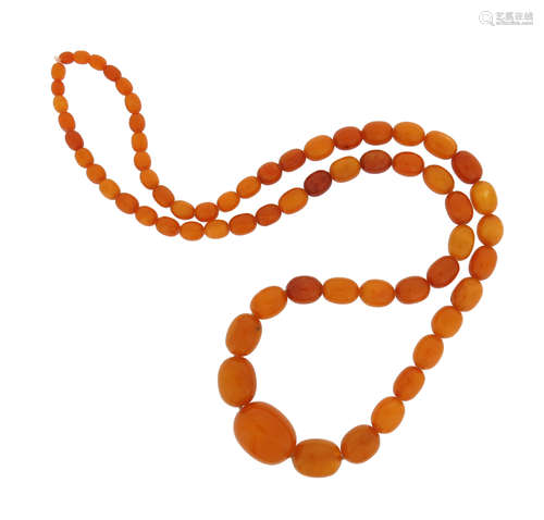 A single-row amber bead necklace, the oval beads graduate from 8 - 30mm long, 95cm long, 82.4g