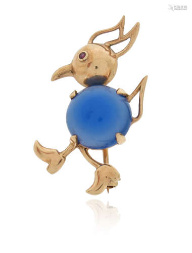 A stylised gold bird brooch, wearing shoes and centred with a circular dyed chalcedony cabochon, red