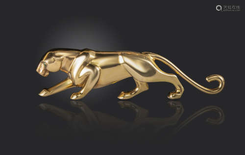 A gold panther brooch by Cartier, of stylised form, set with an onyx nose and emerald eyes in yellow