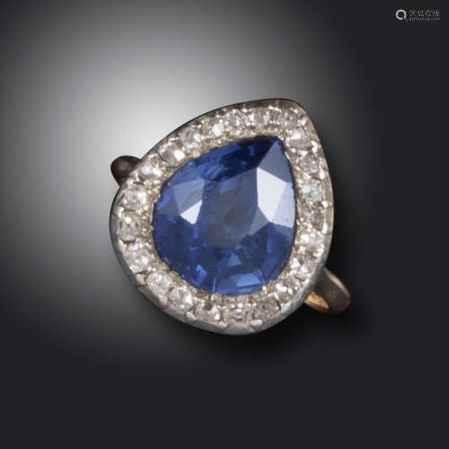 A synthetic sapphire and diamond ring, the pear-shaped synthetic sapphire set within a surround of