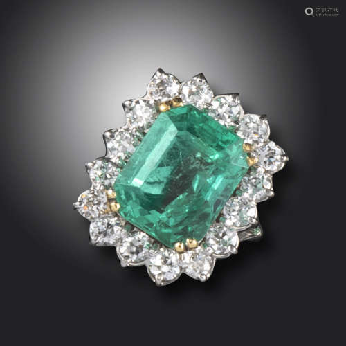 An emerald and diamond cluster ring, the emerald-cut emerald weighs approximately 13.90cts, set