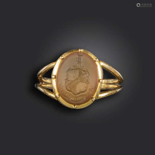 A carnelian intaglio gold signet ring, the oval-shaped carnelian engraved with arms, crest and motto