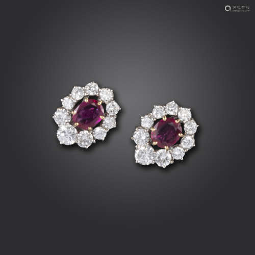 A pair of ruby and diamond cluster earrings, the oval-shaped rubies set within a surround of