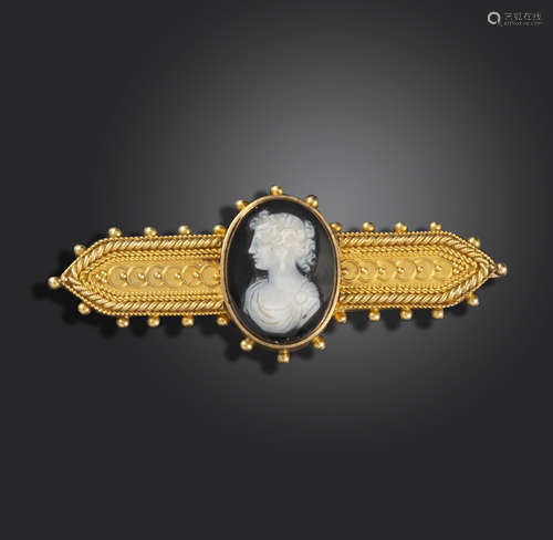 An Etruscan Revival gold brooch, set with a hardstone cameo depicting a portrait of a woman in