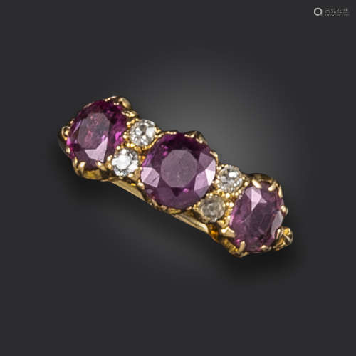 An early 20th century ruby and diamond half-hoop ring, set with three oval-shaped rubies and four