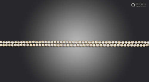 A two-row natural pearl necklace, the pearls graduate from 3.6 - 4.6mm, with a geometric diamond-set