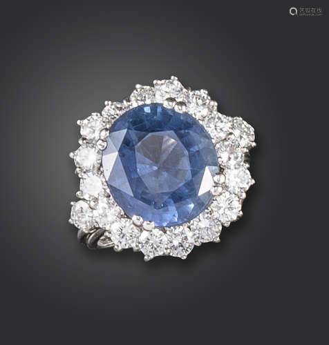 A sapphire and diamond cluster ring, the oval-shaped sapphire weighs 9.71cts, set within an