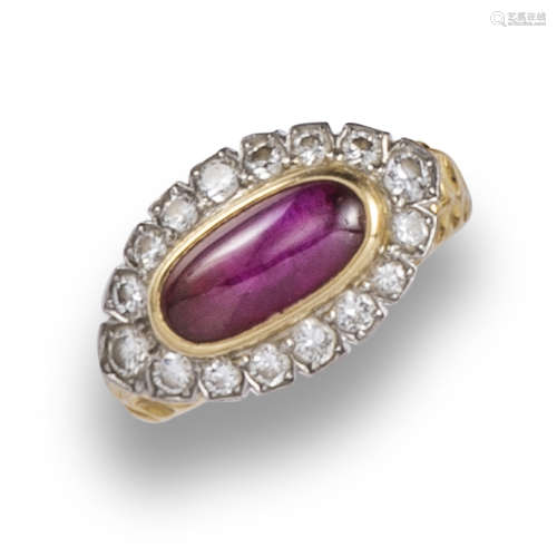 A ruby and diamond ring by Cartier, the oval ruby cabochon set within a surround of diamonds on